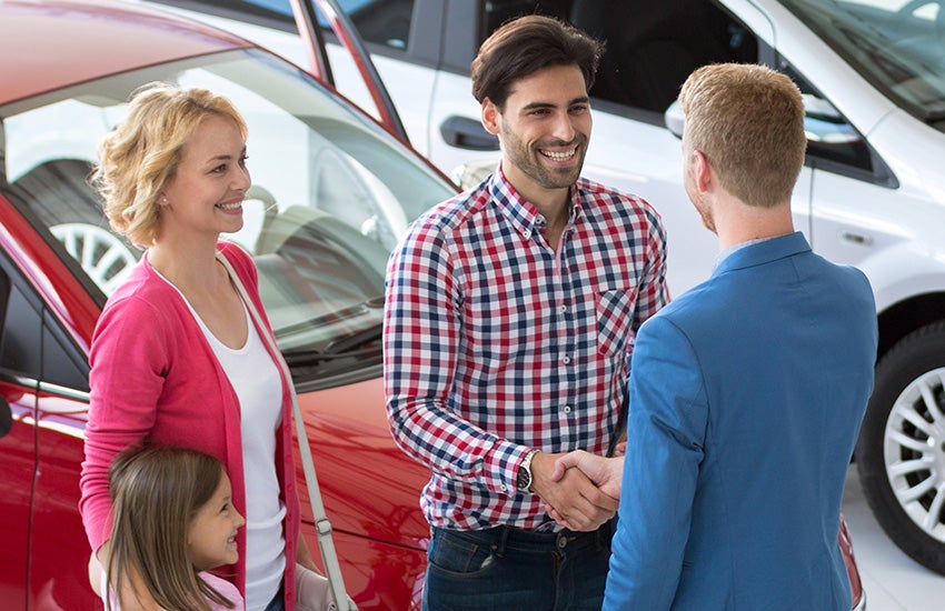 A family looking at a used car